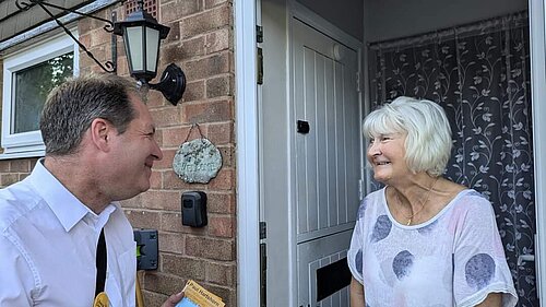 two people at the doorstep talking 